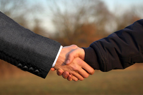 Handshake zwischen Anwalt und Bauer
